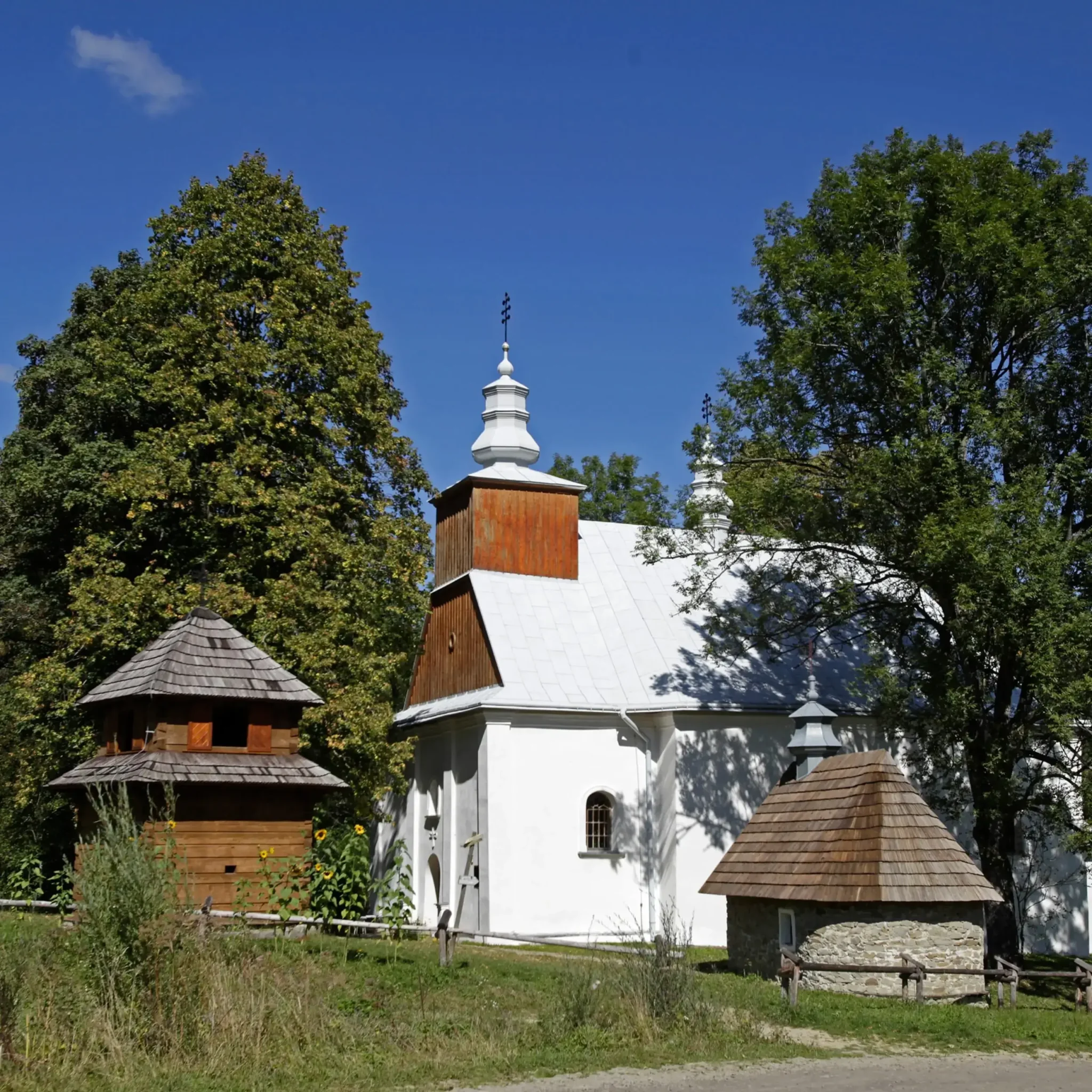 Drewniana cerkiew w Łopience, otoczona malowniczą przyrodą Bieszczad. Zabytkowy obiekt z charakterystycznymi wieżyczkami i dzwonnicą.