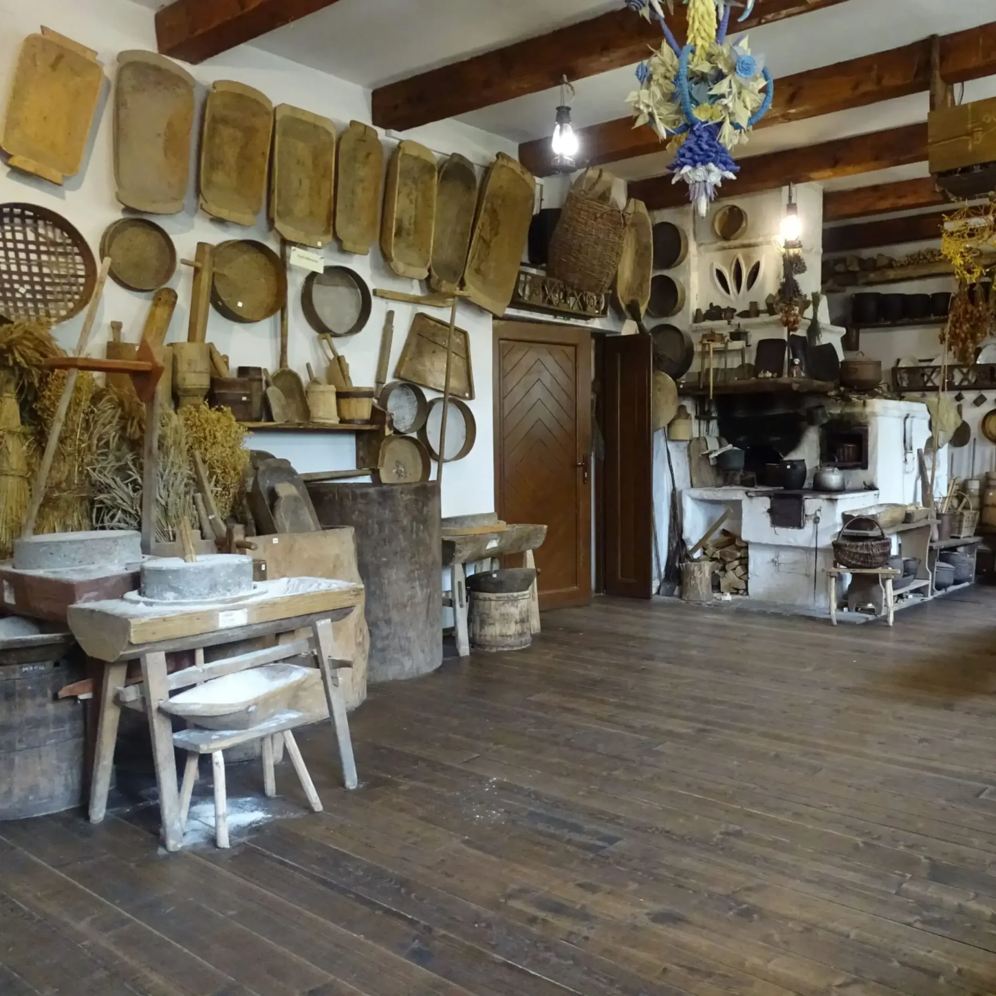 Wnętrze Muzeum Bojków w Bieszczadach, ukazujące tradycyjne narzędzia, naczynia i elementy rzemiosła ludowego charakterystyczne dla regionu.