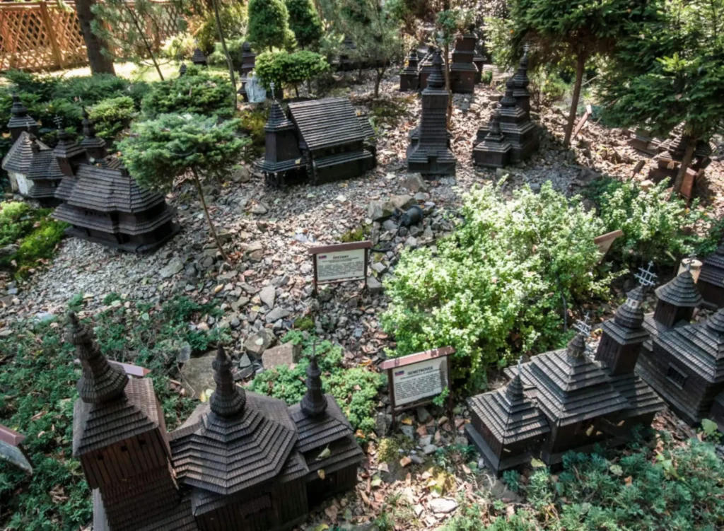 Miniaturowe repliki cerkwi w Bieszczadach w otoczeniu zieleni, przedstawiające tradycyjną architekturę sakralną regionu. Unikalna atrakcja dla miłośników historii i kultury.