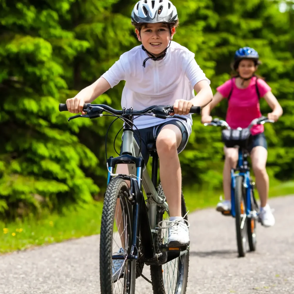 Dzieci na rowerach na leśnej trasie rowerowej w Bieszczadach.